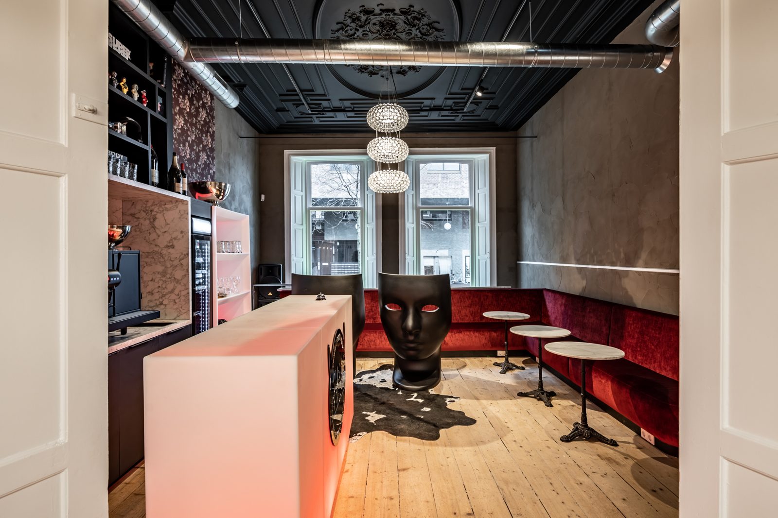 Hotel SuperRebel lounge with red velvet banquette, glowing bar and floral wallpaper