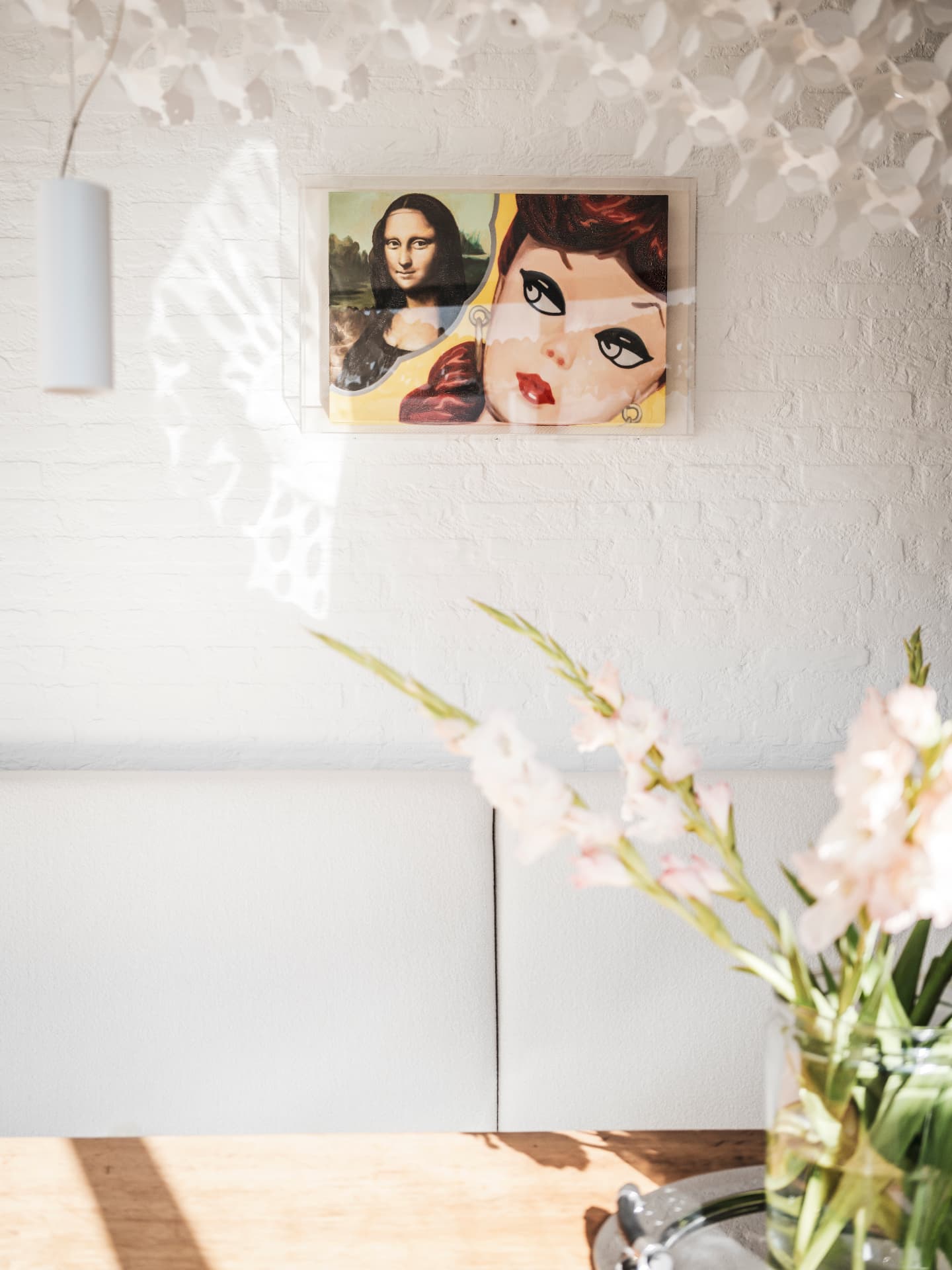 Framed artwork on a white brick wall at B13